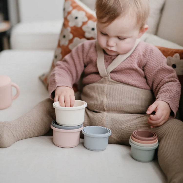 Baby spielt mit Babyspielzeug von Mushie