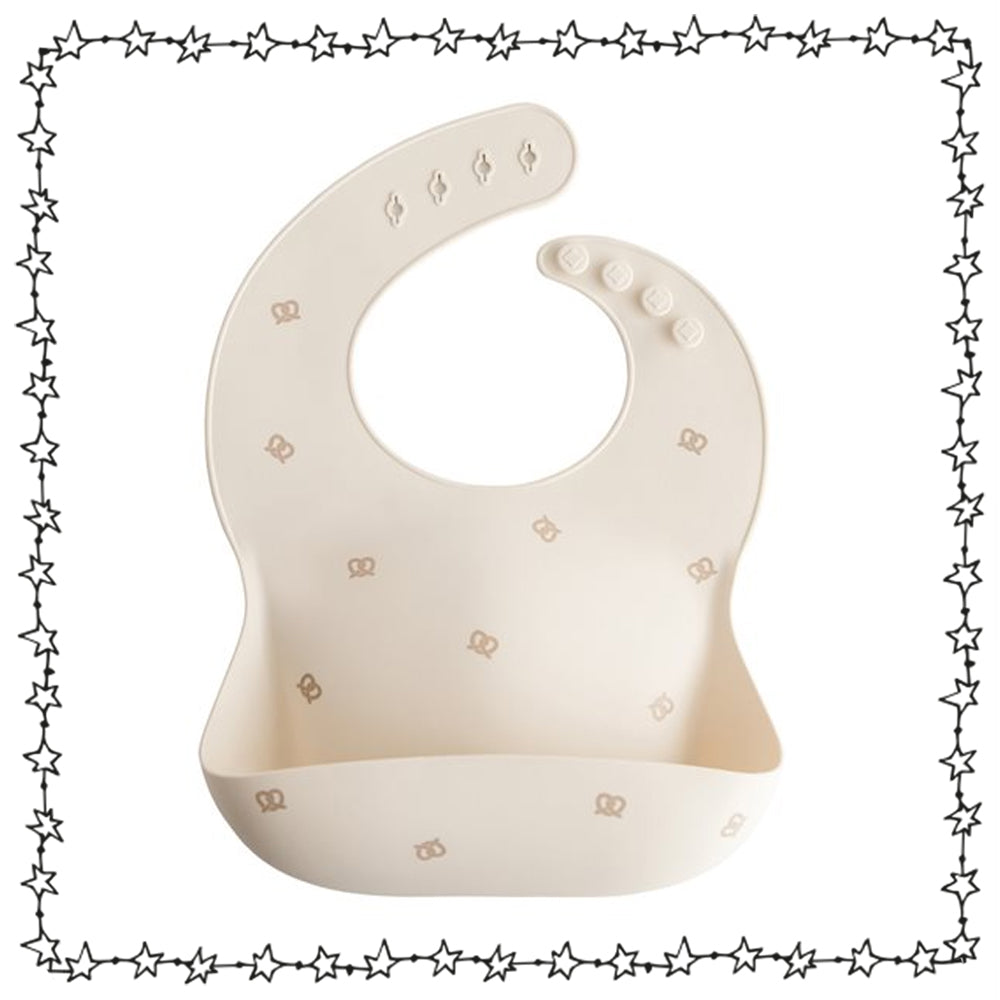 Mushie Silikonlätzchen beige mit Brezenmotiv und Auffangschale