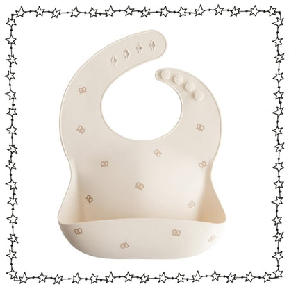 Mushie Silikonlätzchen beige mit Brezenmotiv und Auffangschale