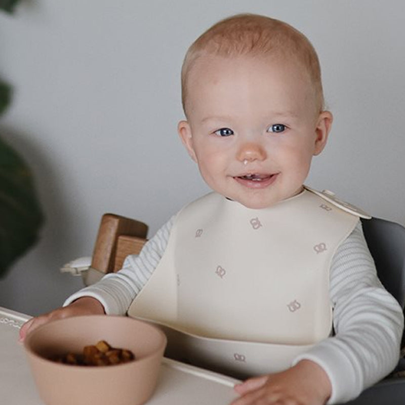 Baby mit Silikonätzchen Breze Mushie bei Babymahlzeit