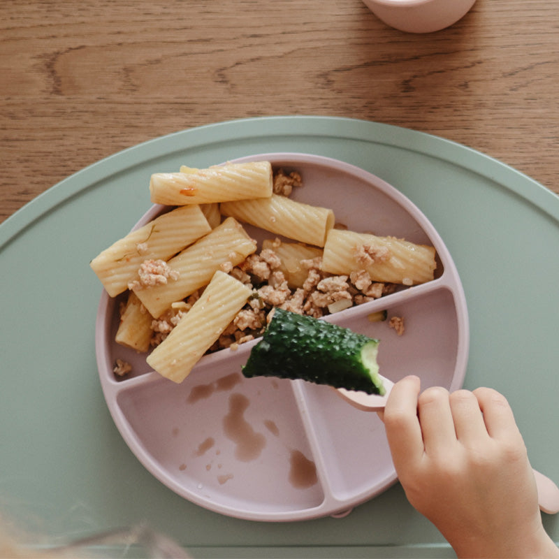 Mushie Silikonteller mit Unterteilung im Einsatz – Perfekt für wählerische Esser und die Förderung der Selbstständigkeit beim Baby-Essen.